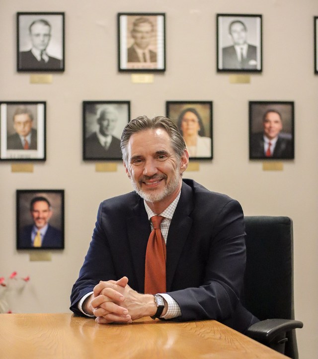 Mike Shipman, Founder of Shipman Law, seated before the Wayne County prosecutors' portrait wall